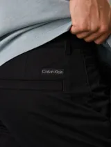 Pantalón chino negro de corte tapered, confeccionado en sarga de algodón elástica. Cuenta con cierre de botón y cremallera, bolsillos con ranura y bolsillos traseros de ojal.