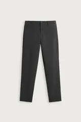 Pantalón de corte slim fit y color negro, confeccionado en tejido elástico. Cuenta con cintura elástica, trabillas, bolsillos frontales y cierre con cremallera y botón.