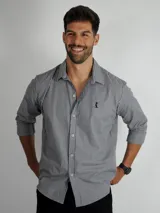 Camisa de manga larga con estampado de rayas verticales finas en tonos gris y blanco. Presenta cuello clásico, cierre frontal con botones y un pequeño logo bordado en el pecho.