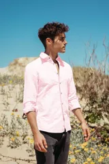 Camisa de lino de manga larga en color rosa claro, con cuello clásico y botones de coco natural.