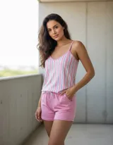 Pijama compuesto por una musculosa de tirantes finos con diseño de rayas verticales en tonos rosados, blancos y azules, y un short liso de color rosado con cordón ajustable en la cintura.