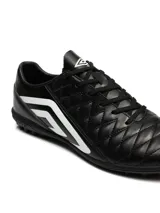 Championes de fútbol Umbro modelo Nexus TF, color negro con detalles en blanco. Presentan una superficie acolchada con costuras en forma de diamante y suela con tapones pequeños ideales para césped sintético.