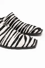 Zueco destalonado confeccionado en cuero con estampado animal print de cebra, punta cuadrada y suela plana de caucho.