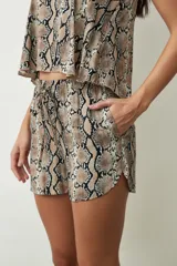 Shorts de mujer color negro con estampado de piel de serpiente, tiro alto y cordón ajustable en la cintura.