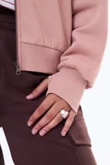 Campera de felpa tipo bomber, color rosado, con cierre frontal completo, cuello redondo y mangas largas con puños ajustados.