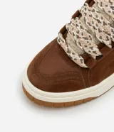 Championes marrones de caña baja, con lengüeta de sherpa color crema y cordones gruesos tricolor.