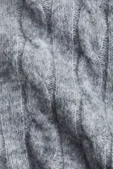 Saco corto de punto trenzado con capucha, cierre frontal y hombros caídos. Presenta puños y bajo en punto acanalado.