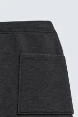 Pantalón de corte wide fit confeccionado en tejido técnico con efecto neopreno. Presenta cintura elástica ajustable con cordón, perneras anchas con costura frontal, bolsillos laterales y bolsillos traseros de plastrón.