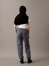 Pantalón de jogging gris de felpa con cintura elástica ajustable con cordón, bolsillos laterales, bajos de canalé y logo CK bordado en la pierna.
