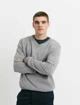 Sweater de punto color ladrillo con cuello en V y mangas largas.