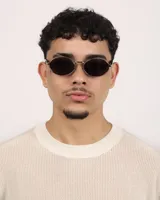 Lentes de sol ovalados con montura plateada y lentes oscuros.