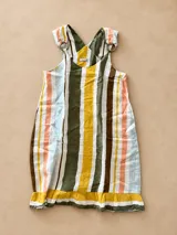 Vestido corto sin mangas de lino con estampado de rayas verticales multicolor en tonos verde, amarillo, marrón, rosado y celeste. Presenta tirantes con argollas metálicas decorativas y un volante plisado en el borde inferior.