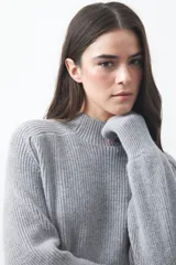 Polera de tejido de punto en color marrón oscuro, con cuello alto y diseño de silueta relajada.