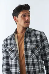 Sobrecamisa de algodón a cuadros color ladrillo, con interior de corderito, cierre con botones, bolsillos tipo cartera y logo en goma. El modelo usa talle M.