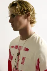 Camiseta boxy fit de cuello redondo y manga por debajo del codo. Presenta un diseño bicolor en tonos blanco off-white y rojo, con estampado y parches frontales con efecto lavado vintage y franjas en las mangas.
