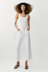 Jeans de tiro alto con diseño de pernera ancha y corte cropped, estilo culotte. Cuenta con cinco bolsillos y cierre frontal con cremallera y botón metálico.