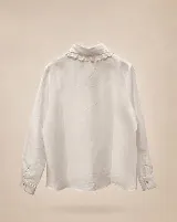 Camisa blanca de lino con cuello tipo Peter Pan amplio adornado con puntilla bordada, cierre frontal oculto y mangas largas con puños rectos.