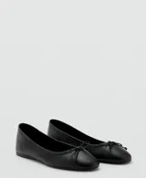 Zapato plano estilo ballerina color negro, confeccionado en cuero vacuno, con puntera redondeada y delicado lazo decorativo en el empeine.