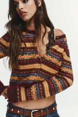 Chaqueta corta de punto con diseño jacquard multicolor, cuello redondo, manga larga y cierre frontal con botones.