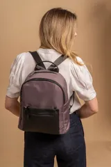 Mochila urbana de diseño combinado, confeccionada en tela resistente con bolsillo frontal y detalles en cuero sintético. Cuenta con compartimento principal con cierre y correas ajustables.