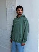 Buzo canguro verde con capucha y cordones ajustables.