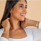 Conjunto compuesto por una cadena fina de eslabones y un dije circular con la imagen de San Benito, ambos realizados en oro 18k.