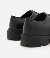 Zapato derby negro de poliuretano para hombre, con diseño robusto, puntera redondeada, cordones y suela tractorada.