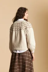 Sweater de tejido jacquard con diseño geométrico en color marrón sobre base beige, de cuello redondo y manga larga con puños ajustados.