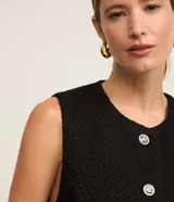 Chaleco blanco de tweed con cuello redondo, abotonado en el frente y corte entallado.