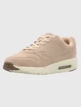 Zapatillas urbanas Hush Puppies modelo Brandhall, confeccionadas en cuero descarne color taupe. Presentan diseño con cordones, suela de EVA con tecnología de amortiguación de aire y detalles de la marca en el lateral y la lengüeta.