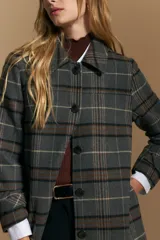 Tapado de paño con estampado a cuadros en tonos gris, marrón y beige. Presenta cuello camisero, cierre frontal con botones oscuros y mangas largas.