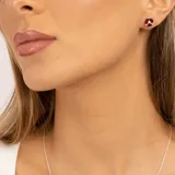 Aros de plata 925 con tres piedras granate y un topacio blanco central.