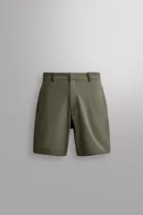 Bermuda de Zara Athleticz color verde militar, confeccionada en tejido técnico compacto y elástico, con bolsillos curvados y cierre frontal con cremallera y botón a presión oculto.