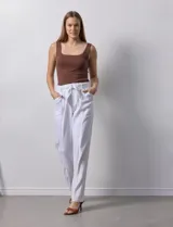 Pantalón blanco de lino con lazo en la cintura, corte recto y bolsillos laterales.
