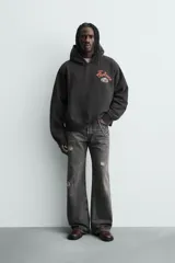 Sudadera con capucha de corte relajado y efecto lavado, confeccionada en mezcla de algodón con interior afelpado. Presenta manga larga, puños y bajo en rib, bolsillo frontal tipo canguro y estampado gráfico de Post Malone en el pecho.