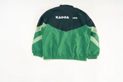 Campera deportiva unisex confeccionada en nylon liviano, color verde y negro, con calce relajado y estructura clásica. Incluye paneles diagonales en contraste y micrográfico Kaboa aplicados al frente y un gráfico en la espalda.