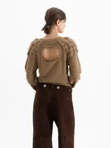 Sweater de punto color marrón, con cuello redondo, mangas largas con efecto globo y volados decorativos en los hombros. Presenta puños y cintura acanalados.