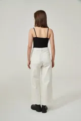 Musculosa de bretel fino color crudo, corte ajustado al cuerpo y escote redondo.