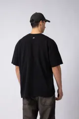 Remera color crudo de corte oversize, con cuello redondo y mangas cortas. Presenta un pequeño bordado de un sol en el centro del pecho.