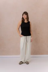 Pantalón crudo de corte amplio y pierna recta, confeccionado en tela liviana con excelente caída. Posee cintura elastizada, cordón de ajuste en contraste y bolsillos laterales.