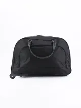 Bolso de viaje negro con ruedas, confeccionado en tela resistente, con cierre principal y bolsillo frontal con cierre. Cuenta con asas superiores para transporte manual.