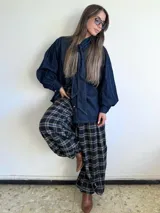 Pantalón de corte amplio y holgado, confeccionado en franela con estampado de tartán escocés en tonos azul, negro y beige. Presenta cintura elástica para un ajuste cómodo.