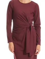 Vestido midi de seda fría color bordó, con cuello a la base, mangas largas y detalle de lazo ajustable en la cintura que crea un efecto drapeado lateral.