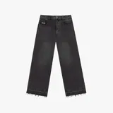 Pantalón de jean negro con corte baggy, de tiro medio y pierna ancha. Presenta un parche de cuero naranja en la cintura trasera y un bolsillo trasero con un parche bordado de la marca Nude Project. El ruedo tiene un acabado deshilachado.