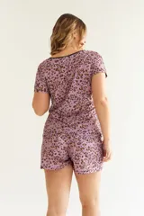 Conjunto de pijama color rosa con estampado de leopardos, detalles de encaje rojo en el escote y mangas de la remera y en el ruedo del short.