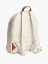 Mochila Tommy Hilfiger de nailon color beige, con diseño curvo, bolsillo frontal con cierre y detalles en cuero sintético marrón en el asa superior. Cuenta con el monograma TH metálico dorado en la parte delantera y correas ajustables.
