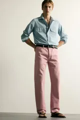 Jeans straight fit de denim de algodón color rosado, con diseño de cinco bolsillos, tiro medio y corte de pierna recta desde la cadera hasta el tobillo. Cuenta con cierre frontal de cremallera y botón metálico.