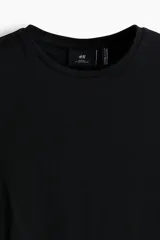 Remera de punto liviano color negro, con cuello redondo y mangas cortas. Diseño slim fit de corte entallado y bajo recto.