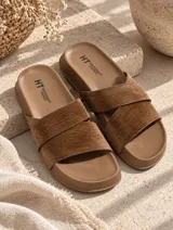 Sandalias planas color marrón con tiras cruzadas y suela moldeada.
