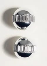 Aros de diseño circular con acabado metálico plateado y detalle de cristales incrustados en el centro.
